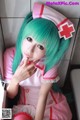 A woman with green hair wearing a pink nurse outfit.