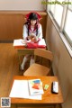 A woman sitting at a desk reading a book.