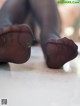 A close up of a person's feet in black stockings.