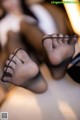 A close up of a person's feet in black stockings.