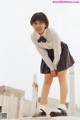 A young girl in a school uniform posing for a picture.