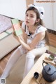 A woman sitting on the floor holding a book.