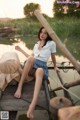 A woman sitting on top of a wooden boat on a lake.