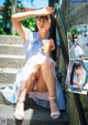 A woman sitting on the steps of a building holding a drink.