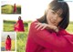 A woman in a red dress posing in a field.