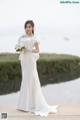 A woman in a wedding dress holding a bouquet of flowers.