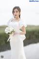 A woman in a wedding dress holding a bouquet of flowers.