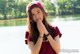 A young woman in a red shirt and a red hat.