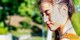 A woman with her eyes closed in a park.