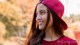 A woman wearing a red hat smiles at the camera.