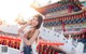 A woman standing in front of a chinese temple.