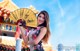 A woman in a cheongsam holding a yellow fan.