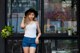 A woman standing in front of a coffee shop wearing a hat.