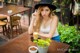 A woman sitting at a table with a cup of coffee.