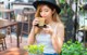 A woman sitting at a table with a cup of coffee.