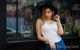 A woman leaning against a window in front of a coffee shop.