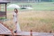 A woman standing on a wooden bridge holding an umbrella.