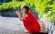 A woman in a red dress crouching down on the ground.