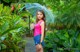 A woman standing in the rain holding an umbrella.