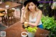 A woman sitting at a table with a cup of coffee.