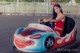 A woman in a red and white dress driving a bumper car.