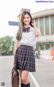 A woman in a school uniform is posing for a picture.