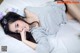 A woman laying on top of a bed next to a stuffed animal.