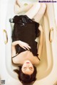 A woman laying in a bathtub with her legs up.