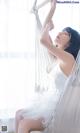 A woman in a white dress sitting in a hammock.