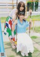 A couple of young women sitting on a swing.