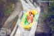 A woman riding a yellow and green tube down a river.