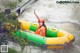 A woman in an inflatable raft on a river.