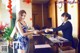 A woman standing at the front desk of a hotel.