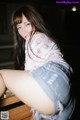 A woman sitting on top of a wooden bench.