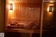 A woman laying on a wooden bench in a sauna.