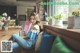 A woman sitting on a couch reading a book.