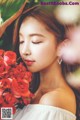 A woman holding a bunch of red roses in her hand.