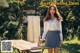 A woman standing next to a picnic table in a park.