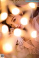 A woman laying on top of a bed covered in lights.