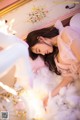 A woman laying on top of a bed covered in cotton.