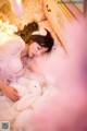 A woman laying on a bed with a stuffed animal.