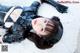 A woman in a black leather outfit laying on a white rug.