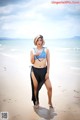 A woman in a bikini standing on a beach.