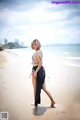 A woman walking on a beach near the ocean.