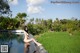 A woman in a bikini sitting on the edge of a pool.