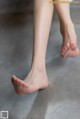 A close up of a woman's bare feet on a concrete floor.