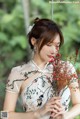 A woman in a white dress holding a bunch of flowers.