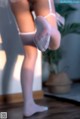 A close up of a woman's legs in white stockings.