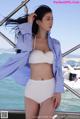 A woman in a white bikini standing on a boat.