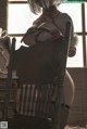 A woman sitting on top of a wooden chair.